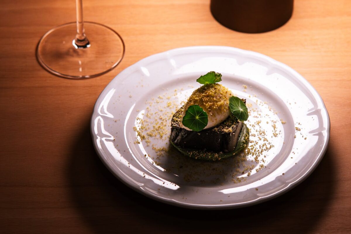 about-us A beautifully plated gourmet dish with a glass of wine in a Tokyo restaurant setting, showcasing fine dining elegance.
